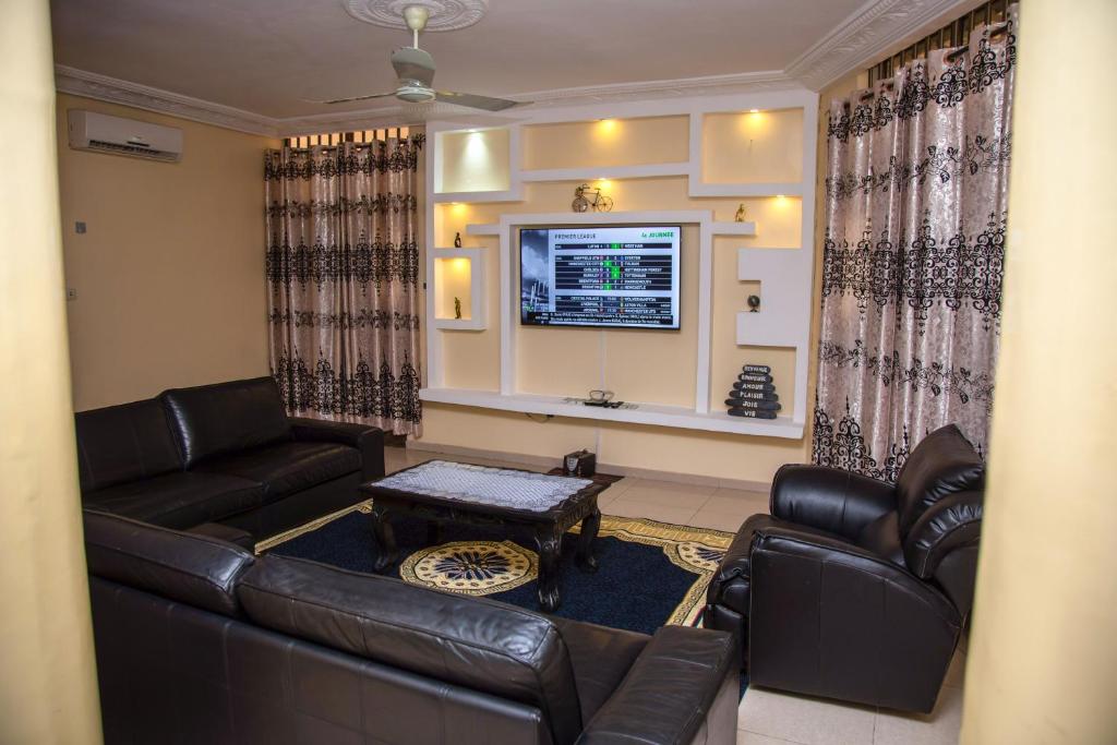 sala de estar con sofá de cuero y mesa en Magnifique Appartement - Cotonou - Avotrou Apkapka en Cotonú