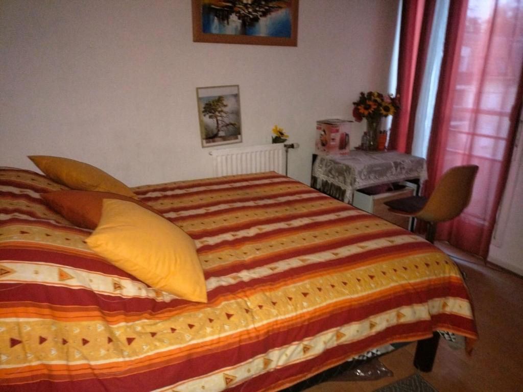 a bedroom with a large bed with yellow pillows at Paris 7 minutes chambre hôte parking avec supplément in Le Kremlin-Bicêtre