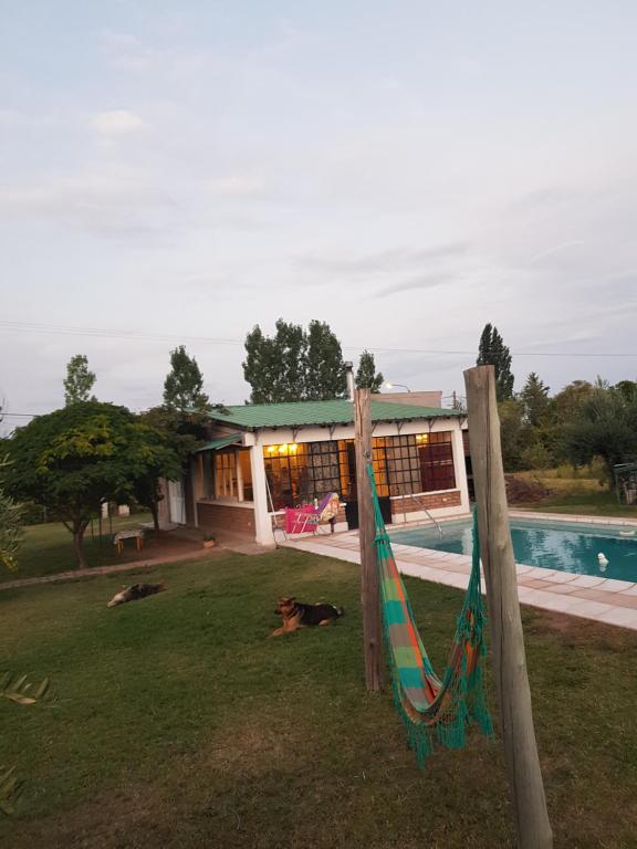 een huis met een hangmat naast een zwembad bij Finca Las Acacias in Maipú
