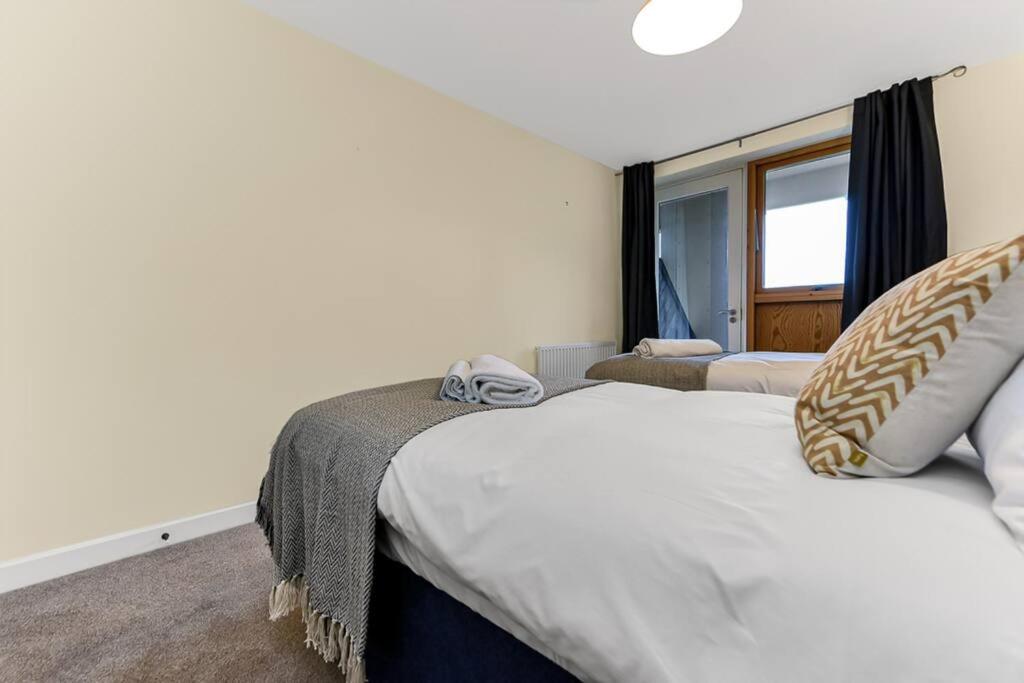 Habitación de hotel con 2 camas y ventana en Scenic Park View Suite, en Milton Keynes
