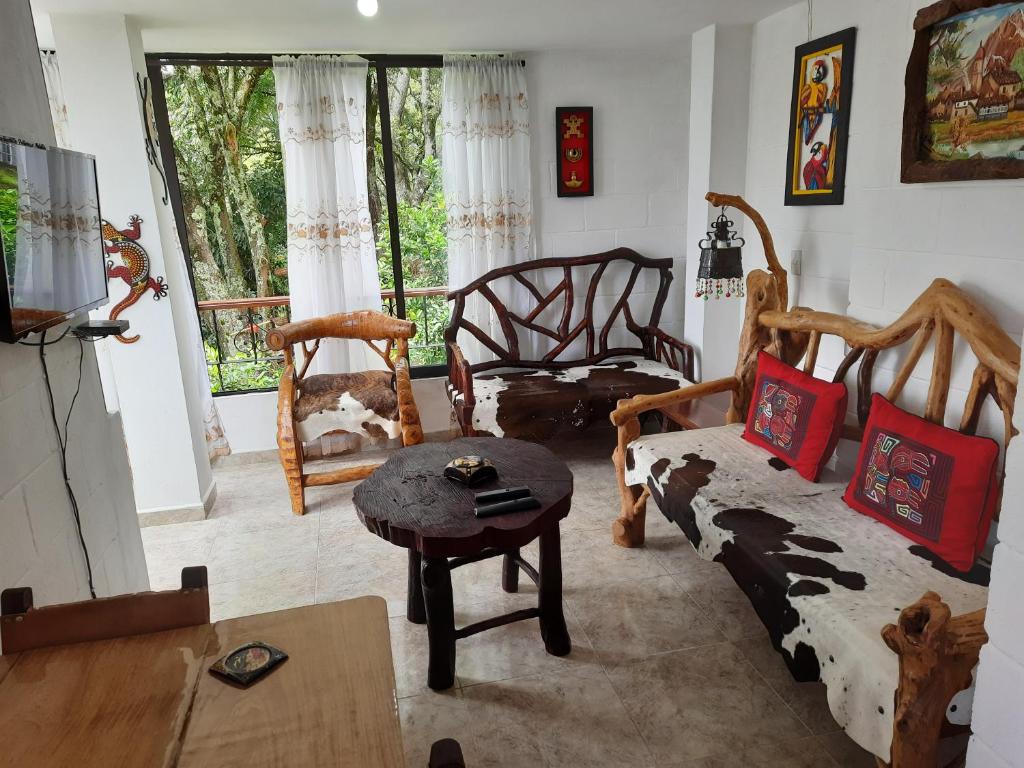 sala de estar con sillas, sofá y mesa en Apartamento Pintoresco Medellín, en Medellín