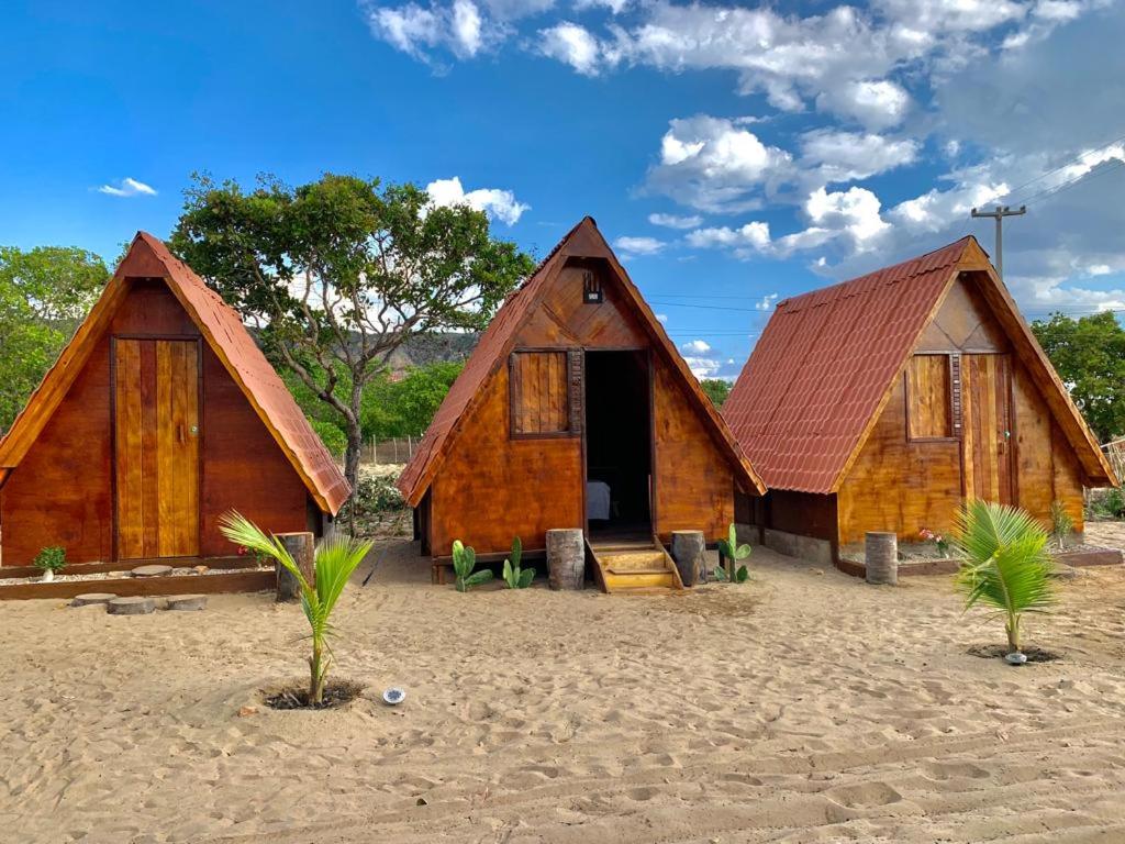 duas cabanas de madeira na areia numa praia em Ecocampingdage em Catimbau