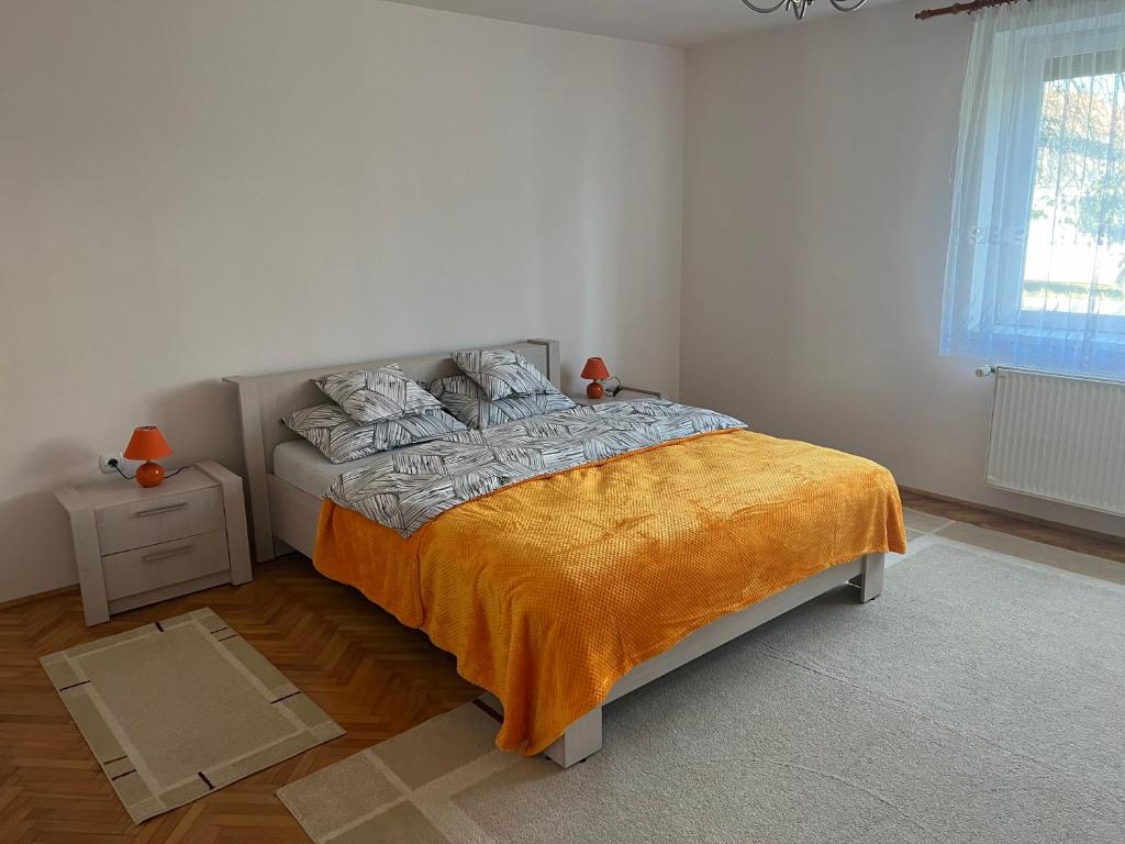 a bedroom with a bed with an orange blanket at Amma House Timisoara in Timişoara