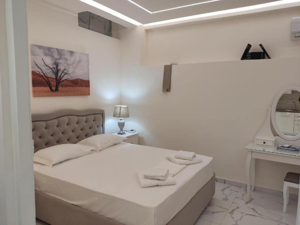 Habitación blanca con cama y espejo en NAFPAKTOS Beach luxury Suites en Nafpaktos