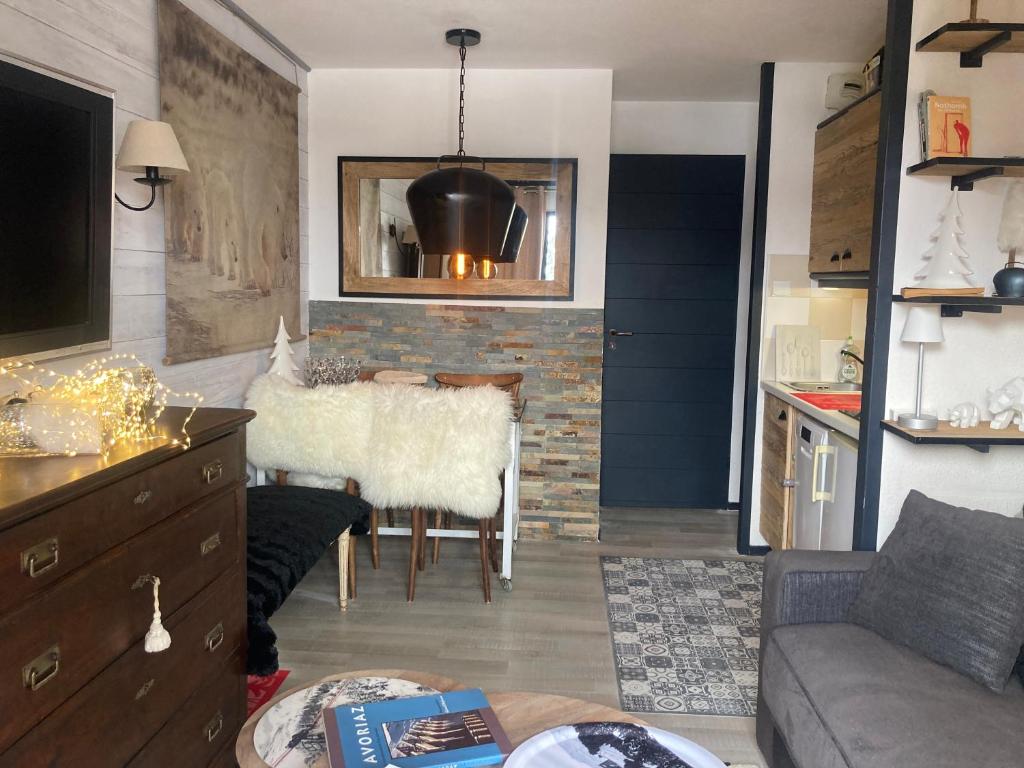 ein Wohnzimmer mit einem Sofa und einem Esszimmer in der Unterkunft Appartement de charme Avoriaz in Avoriaz