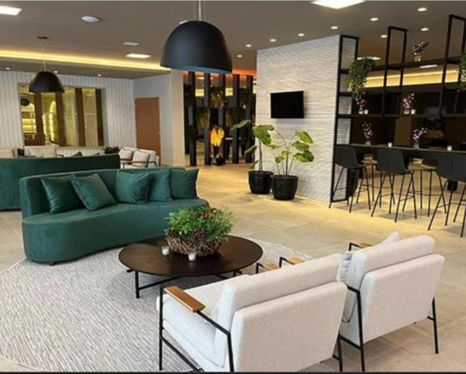- un salon avec un canapé vert et des chaises dans l'établissement Thermas Resort Water Park, São Pedro , à São Pedro