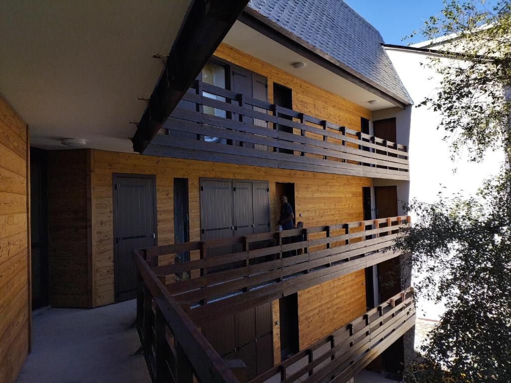 ein Gebäude mit Holzbalkonen auf der Seite in der Unterkunft Appartement en residence in Les Angles