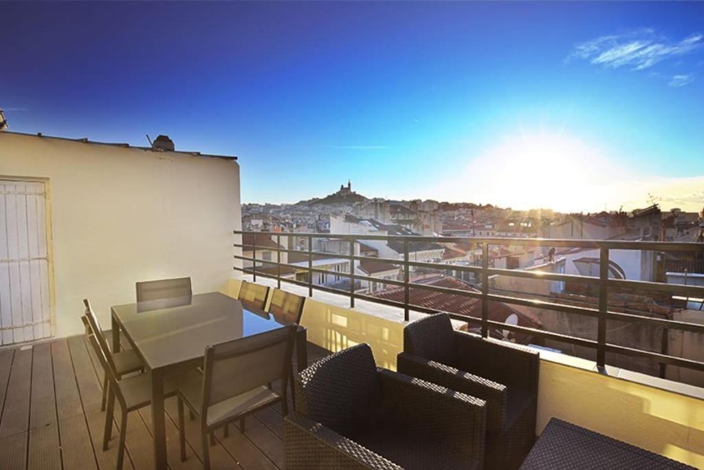 un balcon avec une table et des chaises sur un immeuble dans l'établissement Superbe Appartement Grande Terrasse vue Notre Dame, à Marseille