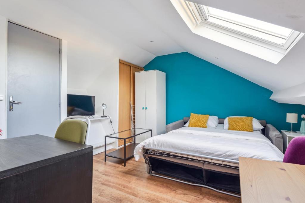 une chambre avec un lit et un mur bleu dans l'établissement Budget appart avec parking au centre-ville, à Charleville-Mézières