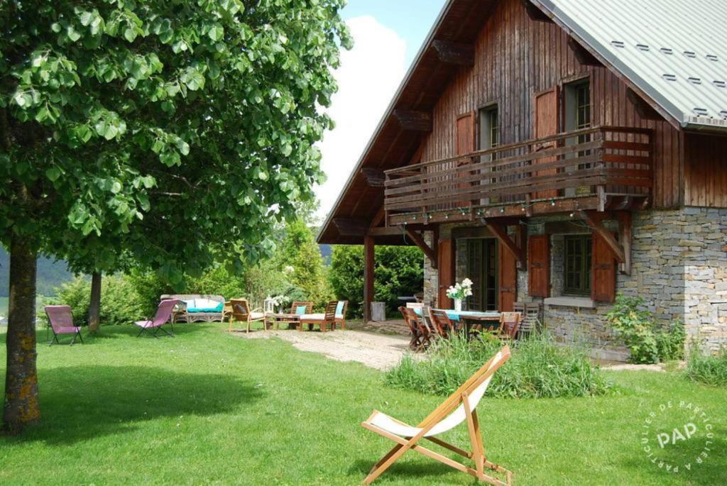 ein Holzhaus mit einem Tisch und Stühlen im Hof in der Unterkunft Les Castors in Villard-de-Lans