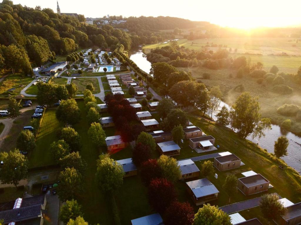 an aerial view of a parking lot with a river at Camping Le Florenville in Florenville