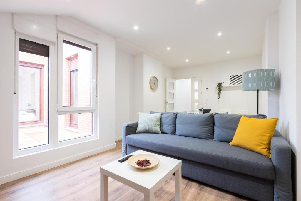 sala de estar con sofá azul y mesa en INSIDEHOME Apartments - La Casita de Irene en Palencia