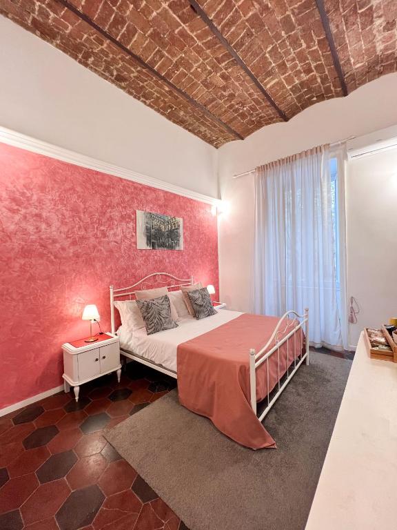 a bedroom with a bed and a red wall at Suite Scarlatti in Naples