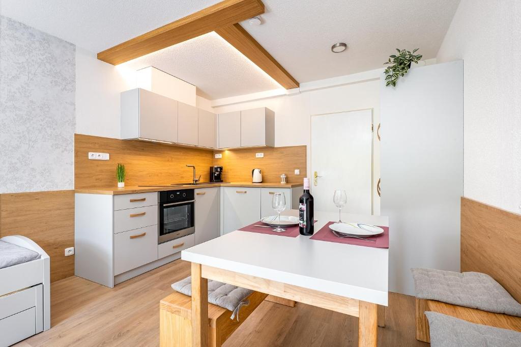 a kitchen with white cabinets and a white table at Apartment Mitterdorf in Mitterfirmiansreut