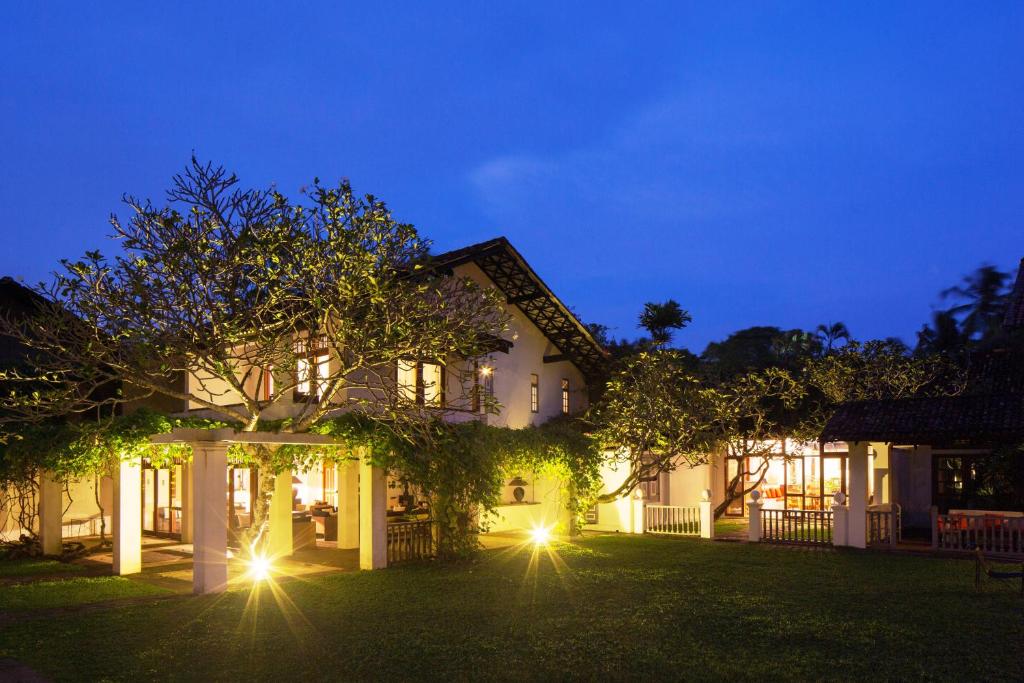 a house with lights in the yard at night at Club Villa in Bentota