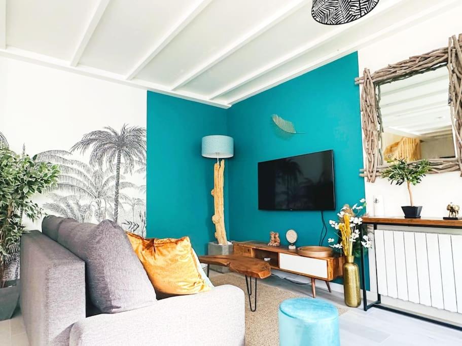 a living room with a couch and a blue wall at LOASIS - Duplex T4 Hypercentre in Villefranche-sur-Saône