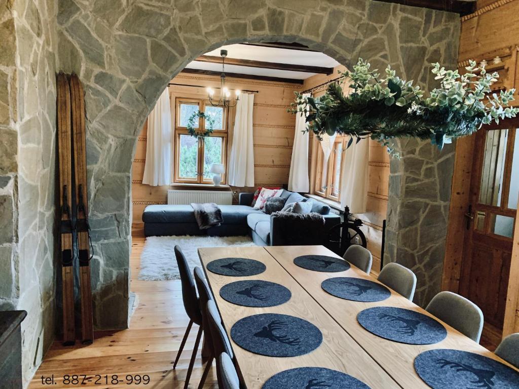a dining room with a table and a couch at Odskocznia House in Szczyrk