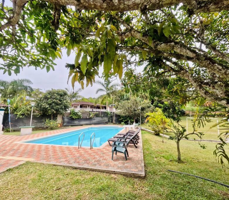 een zwembad met stoelen naast een huis bij finca de descanso y recreacion, fogata,piscina. in Cali