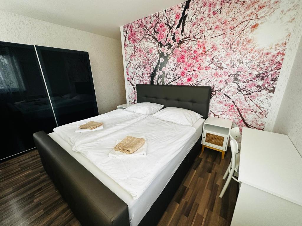 1 dormitorio con 1 cama con un mural de flores en la pared en KVARTYRA 11 DE-LUX, en Jesenice