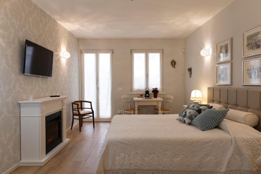 um quarto com uma cama e uma televisão na parede em Casetta al centro em Trento