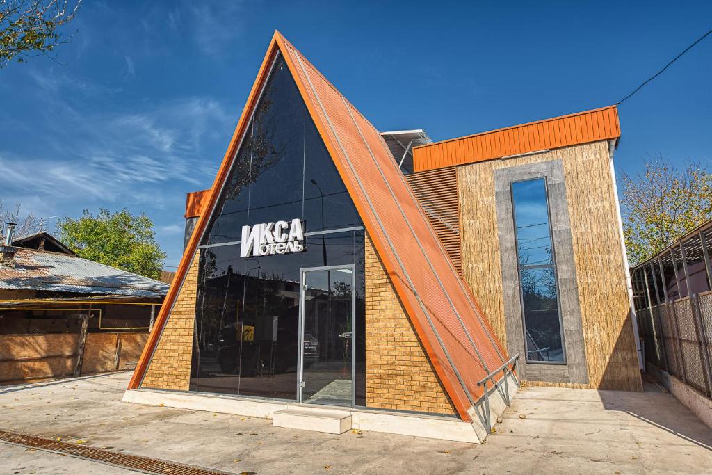 a building with a triangular roof on top of it at ИксаОтель in Shymkent