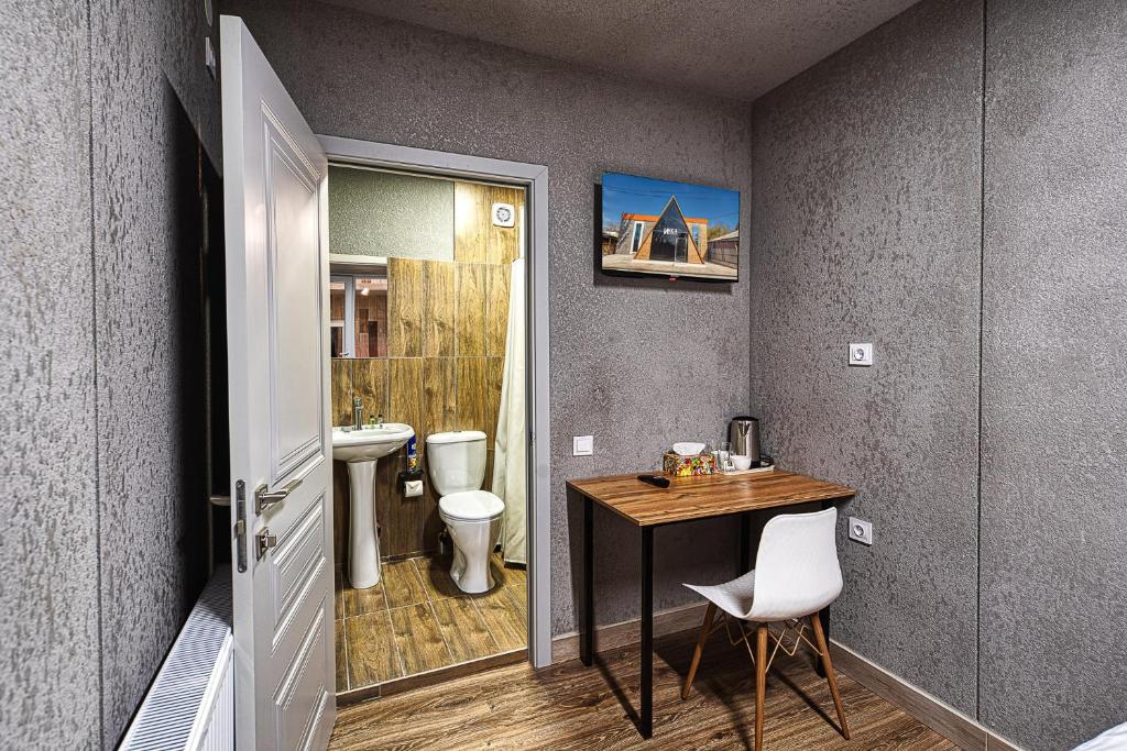 een badkamer met een tafel, een toilet en een wastafel bij ИксаОтель in Simkent