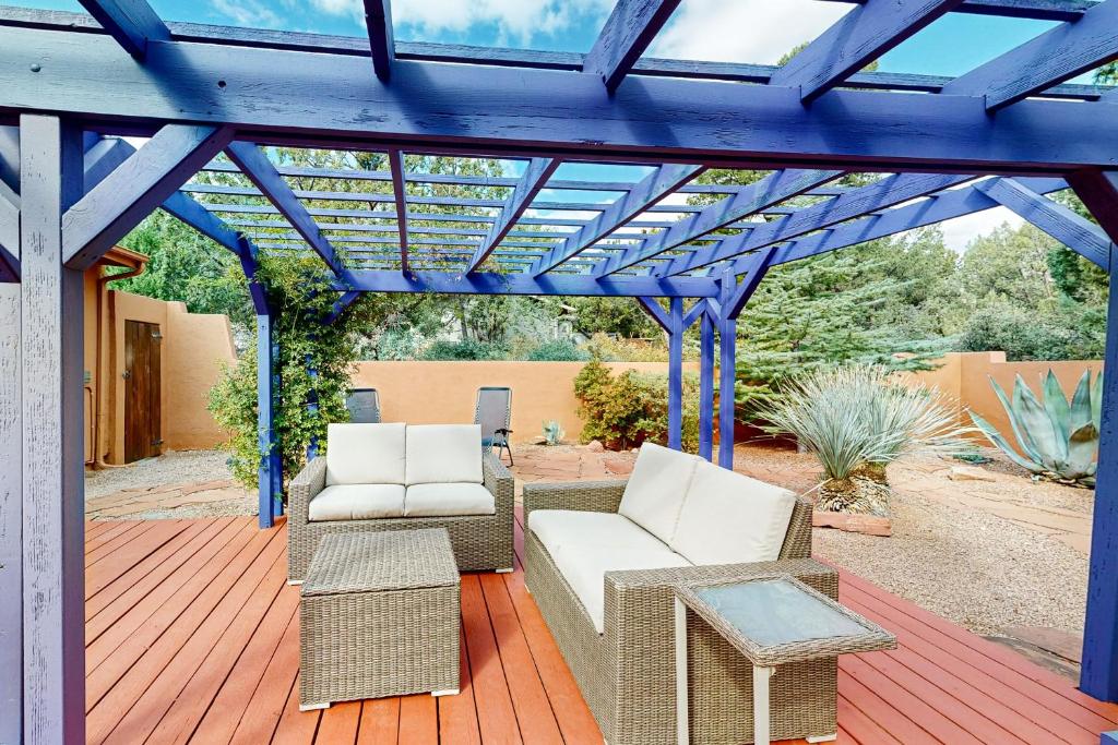 una pérgola con sillas y mesas en una terraza en The Artist's Hideaway, en Sedona