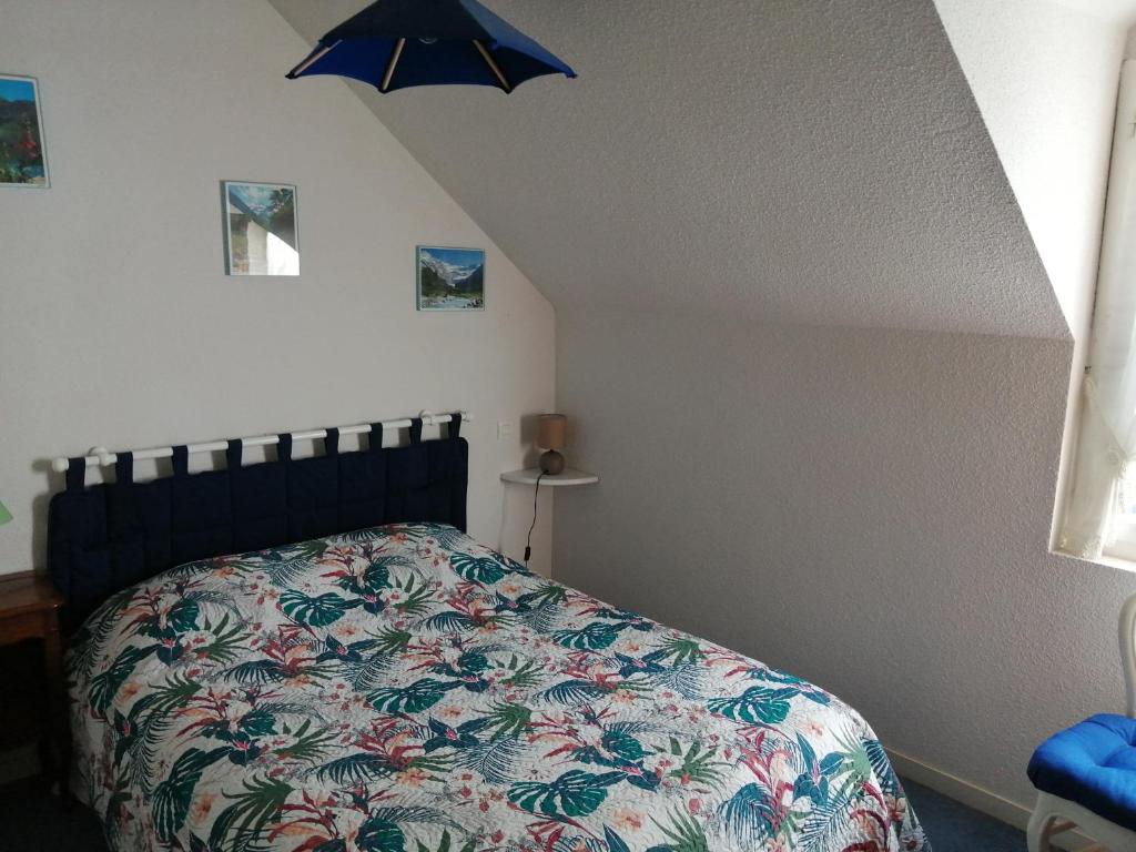 una camera da letto con un letto con un piumone colorato di Appartement type chalet 2 chambres avec terrasse a Cauterets