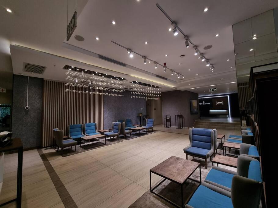 a waiting room with blue chairs and tables in a building at Sandton Skye - luxury apartment in Johannesburg