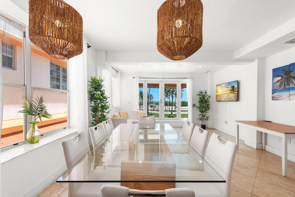 a dining room with a glass table and white chairs at Ocean Drive Apartment Suites in Miami Beach in Miami Beach