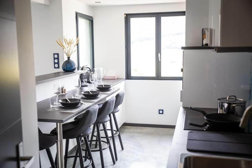uma cozinha com uma mesa com pratos pretos em Bienvenue dans le cobalt ! em Cholonge