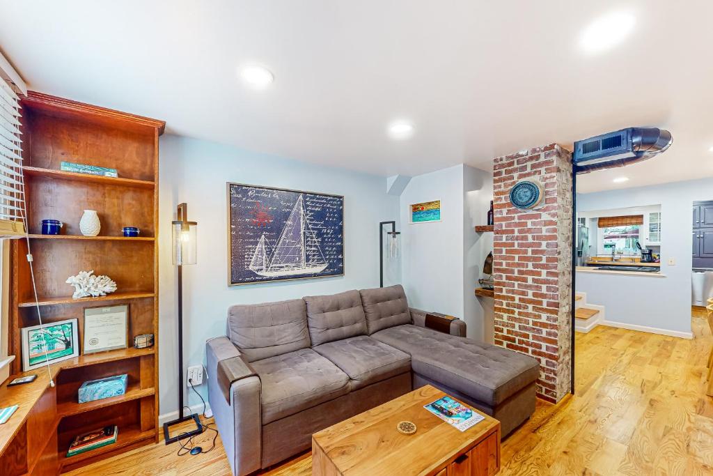 a living room with a couch and a brick wall at Skyline Sanctuary in Annapolis