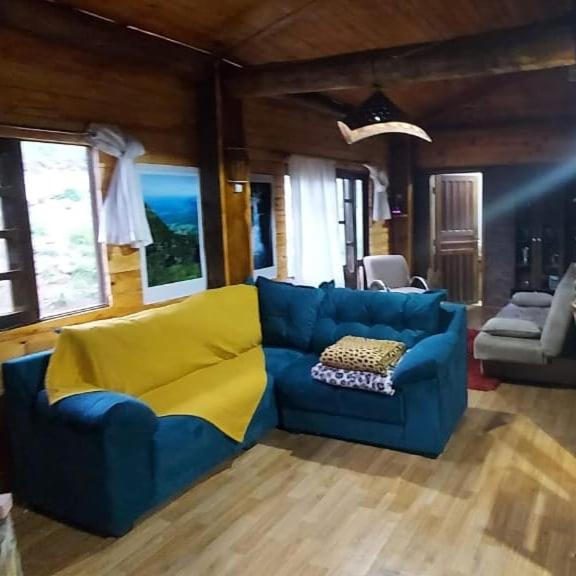 烏魯比西的住宿－Sítio Fundo Da Grota，客厅配有蓝色的沙发和黄色的毯子