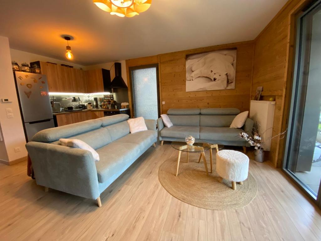 un salon avec un canapé bleu et une table dans l'établissement Appartement proche des pistes Serre Chevalier, à Briançon