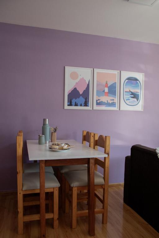 a dining room table and chairs with pictures on the wall at Robinson Alojamientos - Edificio María Gricelda in Ushuaia