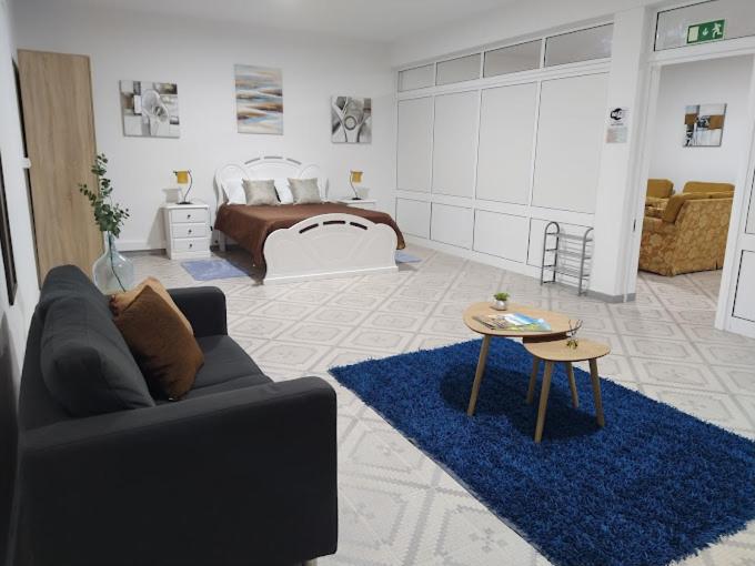 a living room with a couch and a bed at Rua de Baixo Apartments in Calheta