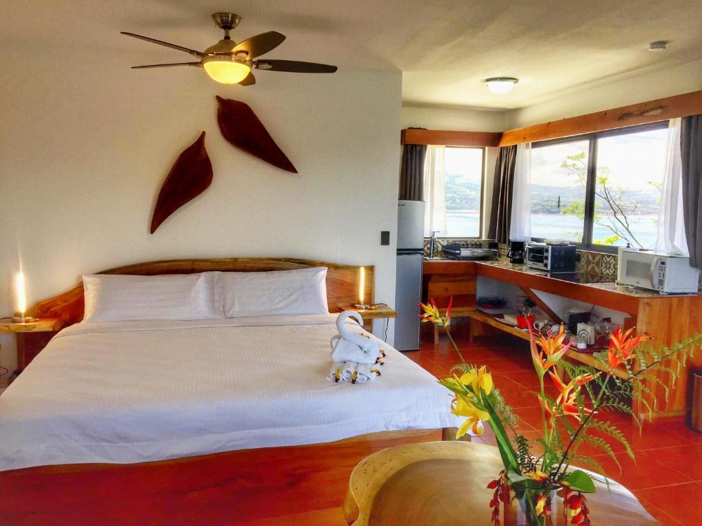un dormitorio con una cama con un osito de peluche sentado en ella en The Fruit Tree Garden Bromeliad Suite en Nuevo Arenal