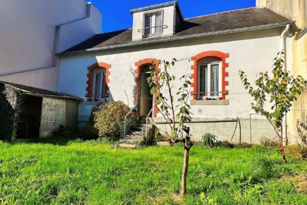 een oud huis met een boom in de tuin bij Chic et cosy maison année 30 in Lorient