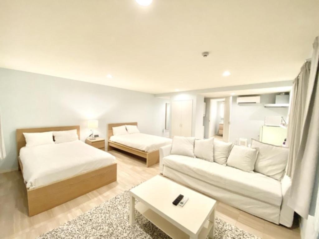 石垣島にあるHOTEL SANDRIVER ISHIGAKIJIMA - Vacation STAY 91470vのリビングルーム(ベッド2台、ソファ付)