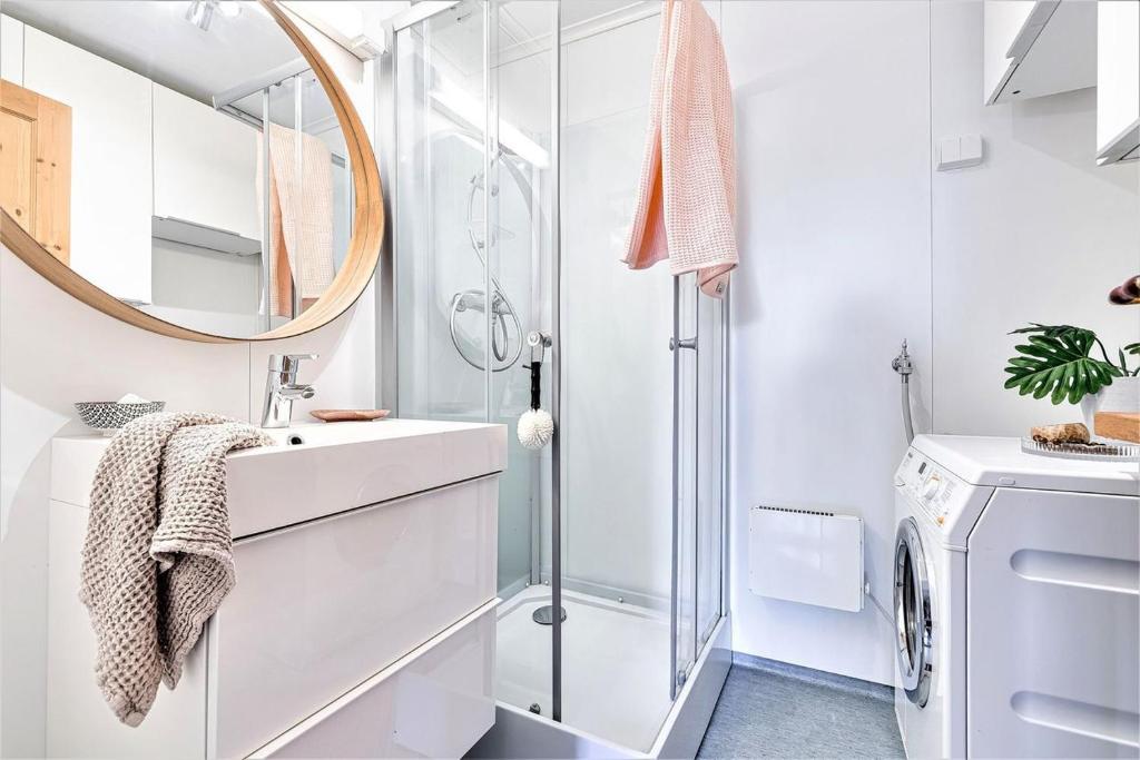 W białej łazience znajduje się umywalka i lustro. w obiekcie Lovely central apartment with two large bedrooms nearby Oslo Opera, vis a vis Botanical garden w Oslo