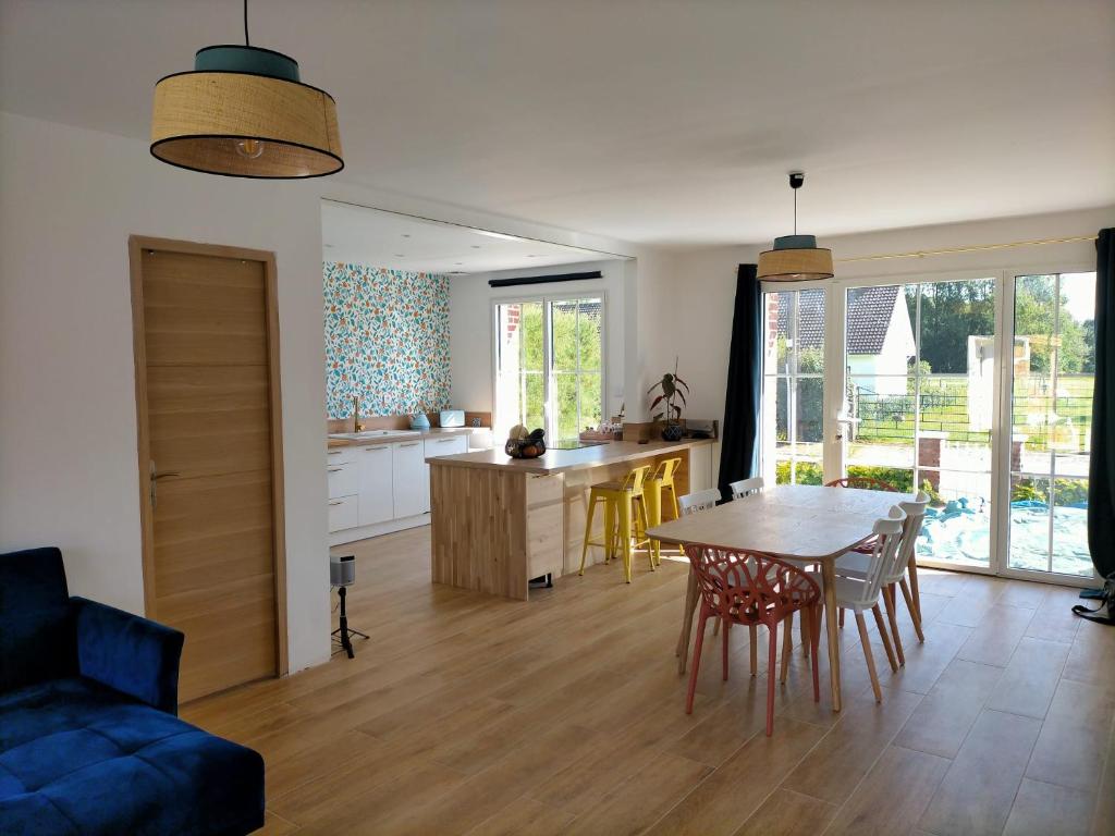 uma cozinha e sala de estar com mesa e cadeiras em Maison du petit p(a)in em Cucq