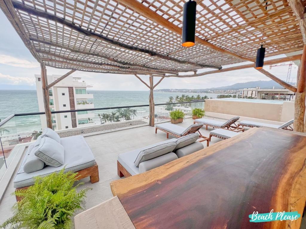 a patio with a table and chairs and the ocean at Arenka - 2BR w Private Pool & Sunset Rooftop in Bucerías