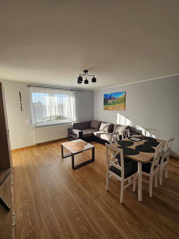 een woonkamer met een bank en een tafel bij Nowa piaskowa apartament in Wągrowiec