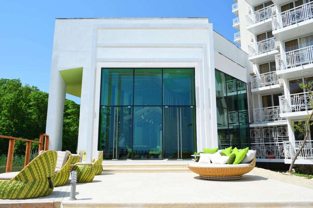 a building with glass doors and chairs in a courtyard at Hotel Gergana in Albena