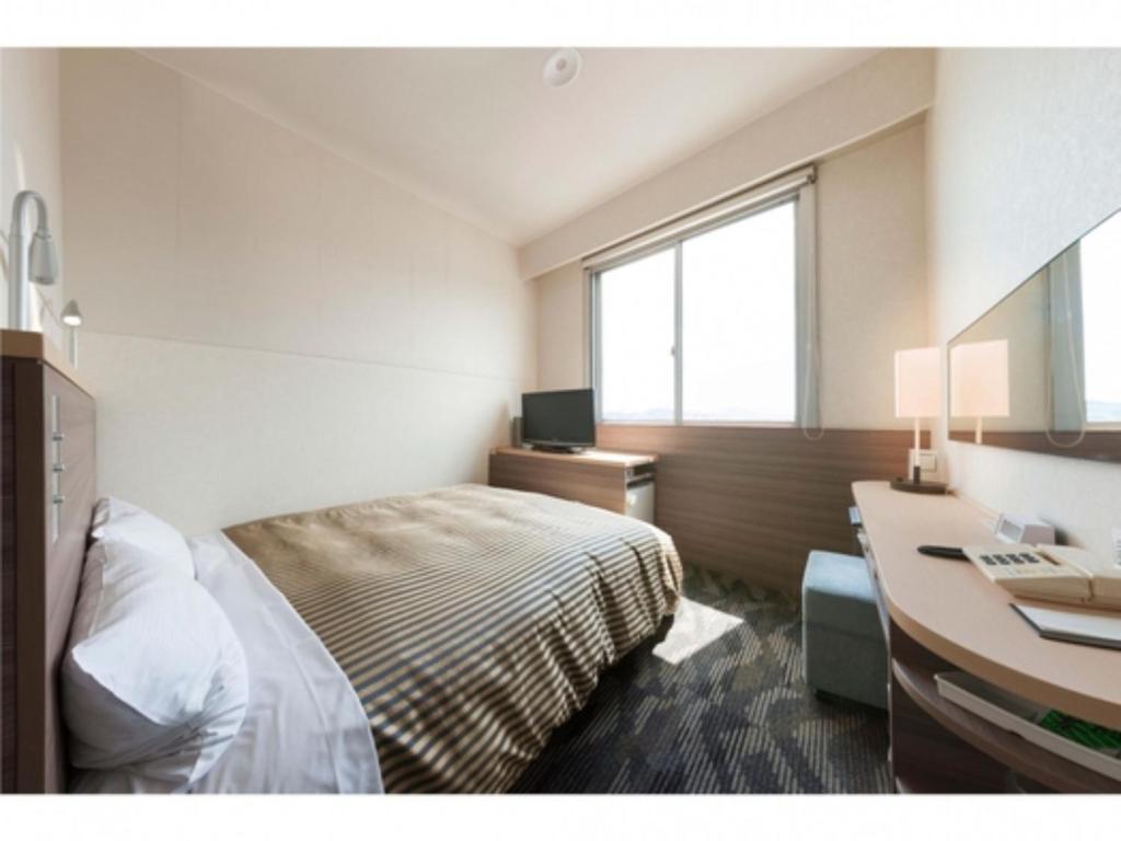 1 dormitorio con 1 cama y escritorio con ordenador en Onomichi Daiichi Hotel - Vacation STAY 02586v, en Onomichi