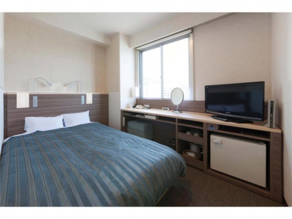 尾道市にあるOnomichi Daiichi Hotel - Vacation STAY 02584vのベッド1台、薄型テレビが備わるホテルルームです。