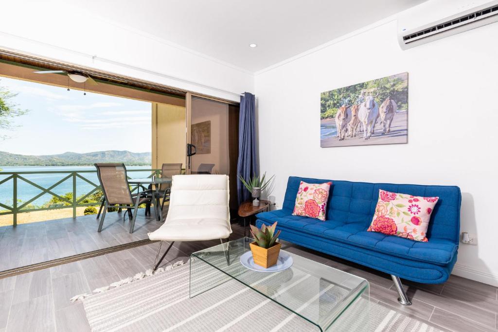 sala de estar con sofá azul y mesa de cristal en Punta Plata 522 - Flamingo Center, 2BR Oceanview condo, near to beach, en Playa Flamingo