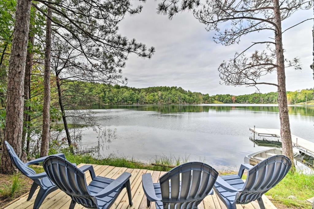 drie stoelen op een steiger naast een meer bij Quiet Retreat on Lake with Kayaks, Boats and Bikes! in Wautoma