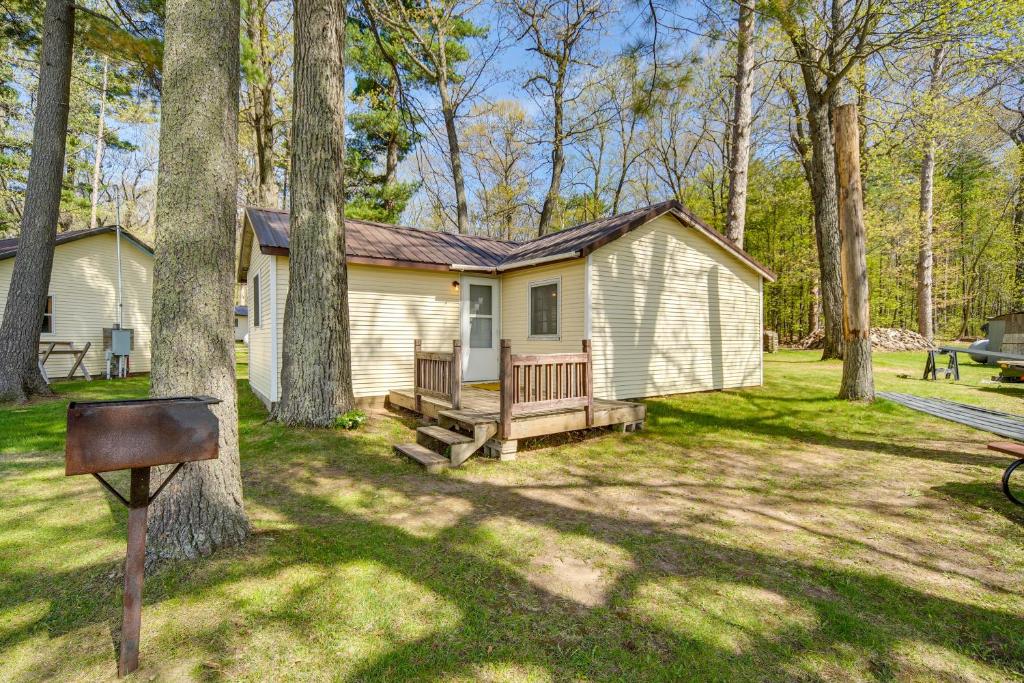 a small house in the middle of a yard at Stone Lake Cabin with Private Deck and Fire Pit! in Northwoods Beach