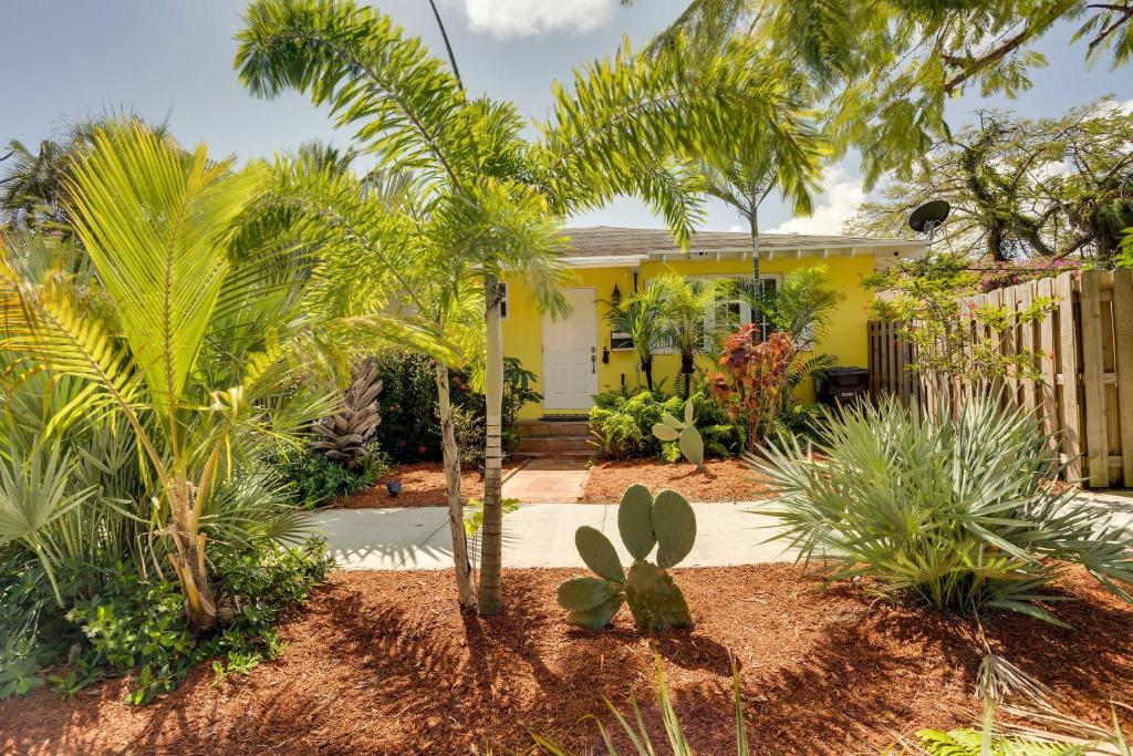 una casa gialla con palme di fronte di West Palm Beach Home with Fenced-In Yard and Deck! a West Palm Beach